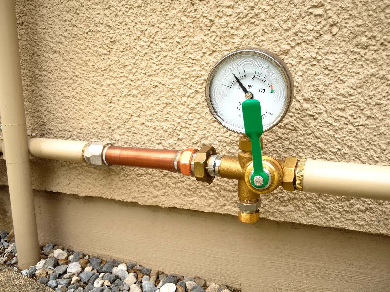 Professional outdoor plumbing equipment with pressure gauge and brass fittings on copper pipes